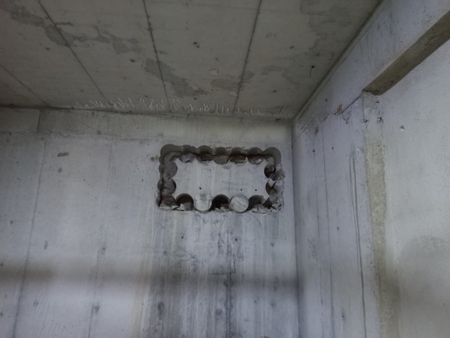 Beton duvarda grup halinde açılmış karot delikleri.